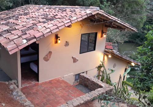 Casa pequeña con techo de baldosa en Hotel Casas de Campo El Ciruelo, en San Gil