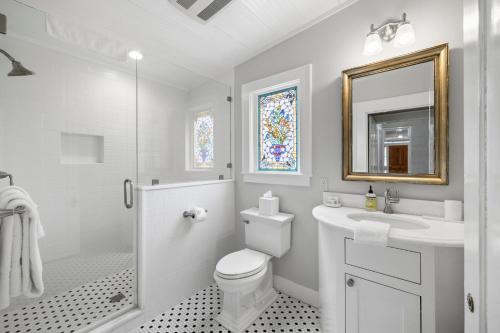 a bathroom with a toilet and a sink and a mirror at Blacksmith Quarters in Fredericksburg