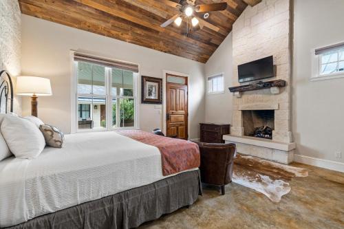 a bedroom with a large bed and a fireplace at Blacksmith Quarters in Fredericksburg