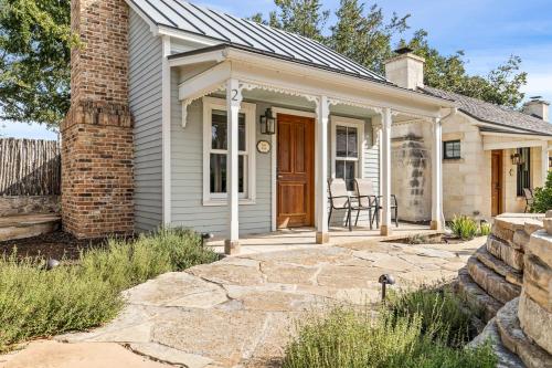 a white house with a porch and a brick pillar at Blacksmith Quarters in Fredericksburg