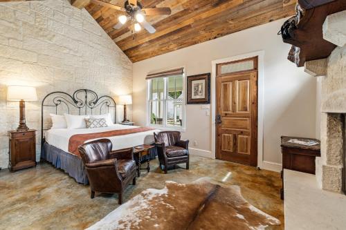 a bedroom with a bed and chairs and a fireplace at Blacksmith Quarters in Fredericksburg