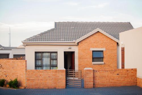 a brick house with a fence in front of it at Marelden estate in eMalahleni