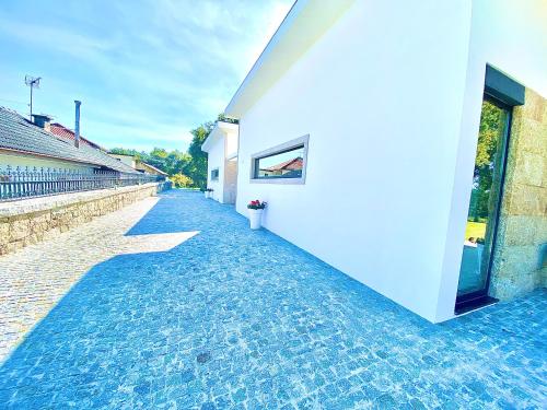 a cobblestone sidewalk next to a white building at CASA TAPADA DA CHEDA 2 in Celorico de Basto