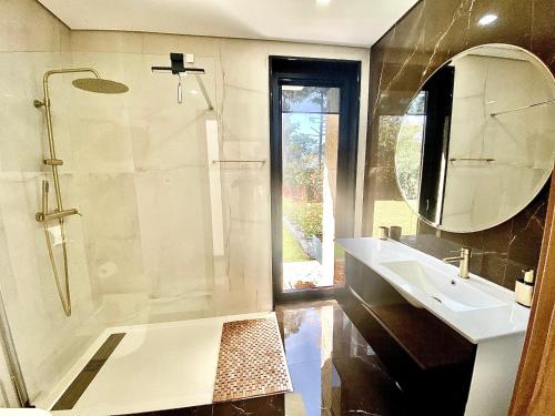 y baño con ducha, lavabo y espejo. en CASA TAPADA DA CHEDA 2, en Celorico de Basto