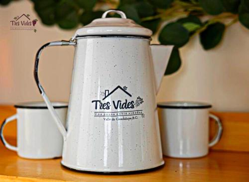 einen Teekessel auf einem Tisch neben drei Tassen in der Unterkunft Tres Vides Hotel Boutique in Valle de Guadalupe
