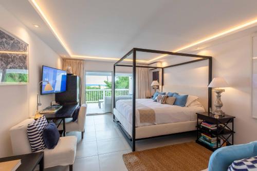 Anse des CayesにあるArt et mer suite Saint barthのベッドルーム1室(ベッド1台、デスク、コンピュータ付)