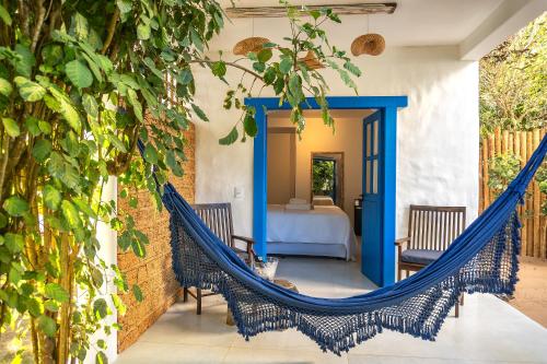 a hammock on a patio with a bedroom at Awe Villa Boutique Trancoso in Trancoso