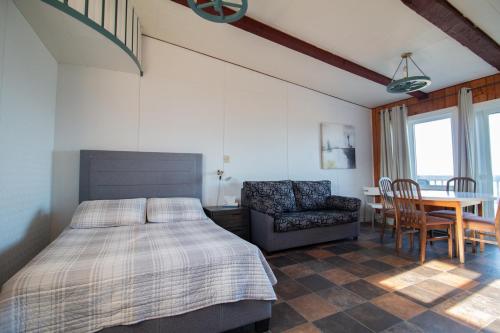 a bedroom with a bed and a table and a chair at Motel de la mer in Rimouski