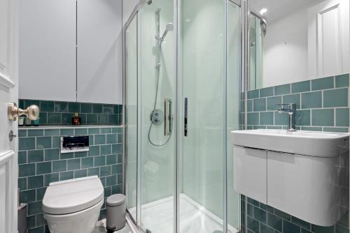 a bathroom with a shower and a toilet and a sink at Londwell, Central Chic, Luxury Stay by Hyde Park in London