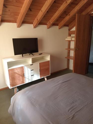 um quarto com uma cama e uma televisão de ecrã plano em Casita 2 ambientes em San Carlos de Bariloche