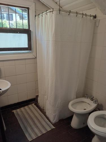 uma casa de banho com um WC e uma cortina de chuveiro em Casita 2 ambientes em San Carlos de Bariloche