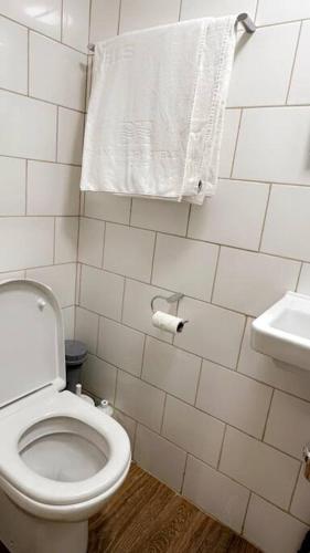 a white bathroom with a toilet and a sink at Cosy Quiet Single Studio in Merton