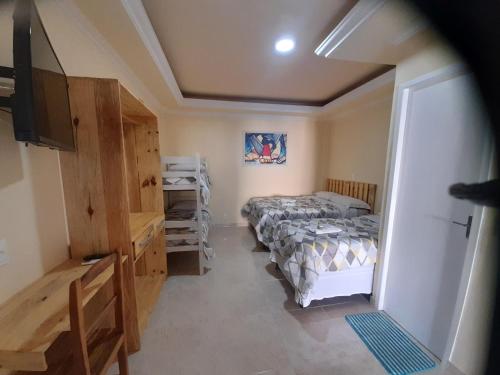 a small bedroom with two beds and a television at Pousada Ceará - Porto das Dunas in Aquiraz