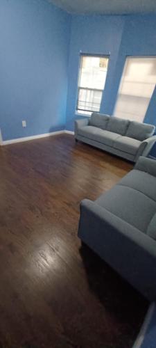 a living room with two couches and a wooden floor at willoughby inn in Newark