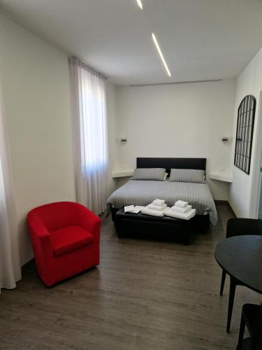 a bedroom with a bed and a red chair at Casa Antelami in Salsomaggiore Terme