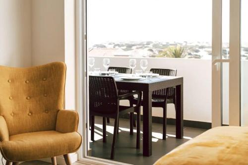 een tafel en stoelen in een kamer met een raam bij Sea View Baleal in Peniche