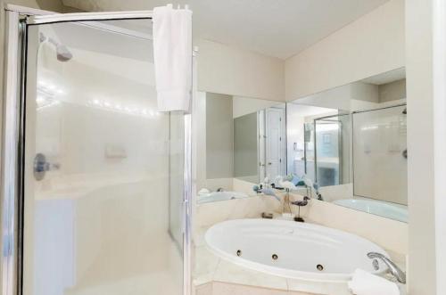 a white bathroom with a tub and a shower at Grand Pointe Unit 414 in Orange Beach