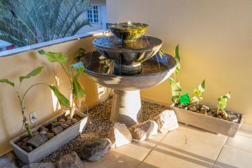 a water fountain in the corner of a room with plants at Pousada Ceará - Porto das Dunas in Aquiraz