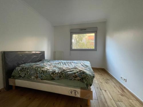 a bedroom with a bed and a window at Nuit Étoilée in Aubervilliers