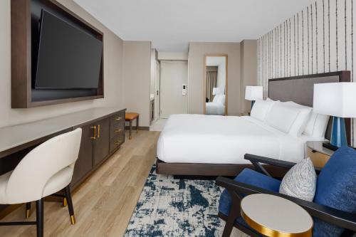 a hotel room with a bed and a flat screen tv at DoubleTree by Hilton Charlotte City Center in Charlotte
