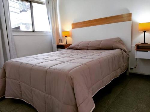 a bedroom with a large bed and two windows at Departamento amplio, cerca de todo in Guaymallen