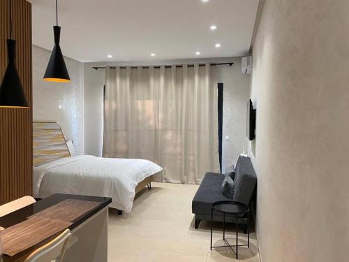a bedroom with a bed and a desk with a television at Studio à Prestigia HayRiad/Rabat in Rabat