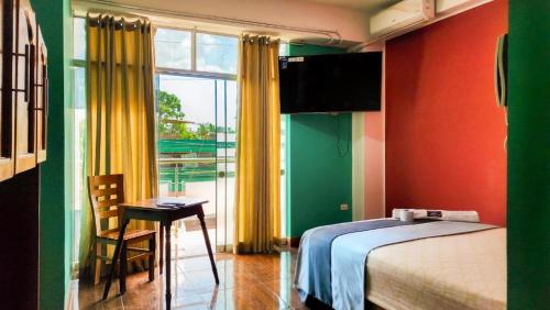 1 dormitorio con cama, mesa y ventana en Hotel LUCHINE en Pucallpa
