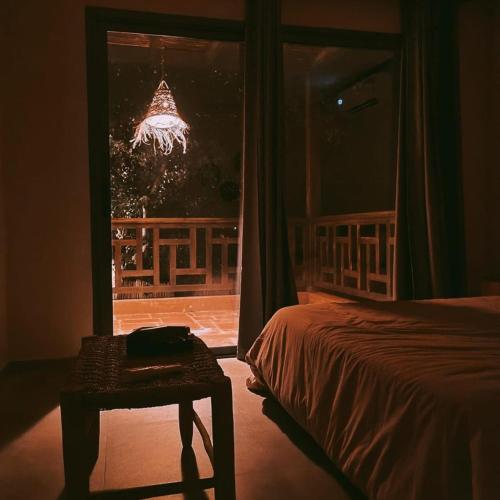 a bedroom with a bed and a table and a window at Le Figuier du Lac Bin elouidane in Bine el Ouidane