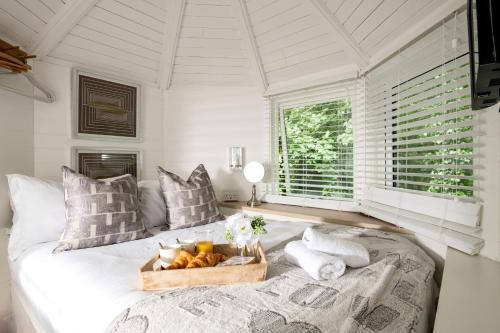 Un dormitorio con una cama con una bandeja de fruta. en Honeycombe - Treehouse in the Heart of Dorset en Blandford Forum