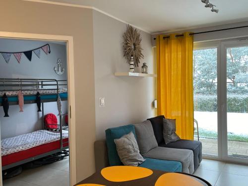 un soggiorno con divano e letto a castello di Bursztynowy Apartament a Jantar