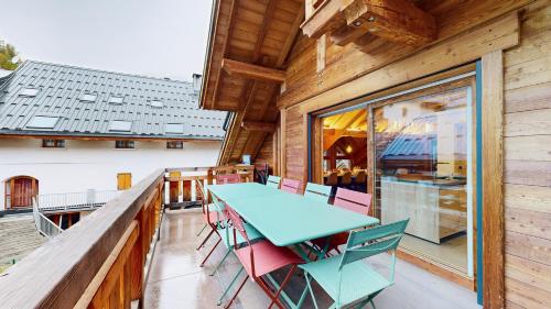 - une table et des chaises sur le balcon d'une cabine dans l'établissement Chalet Sétaz, à Valloire