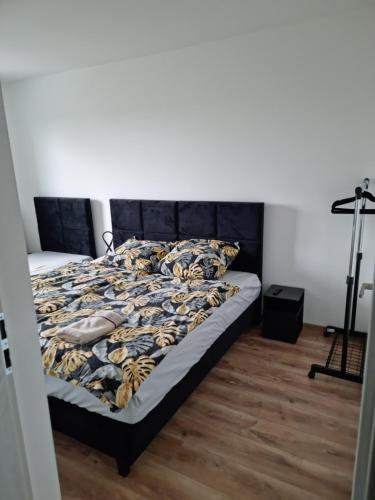 1 dormitorio con 1 cama con cabecero negro en Perłowy Apartament, en Kutno