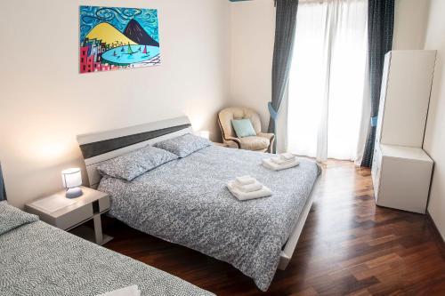 1 dormitorio con 2 camas y 1 silla en Sogno o son desto en Nápoles