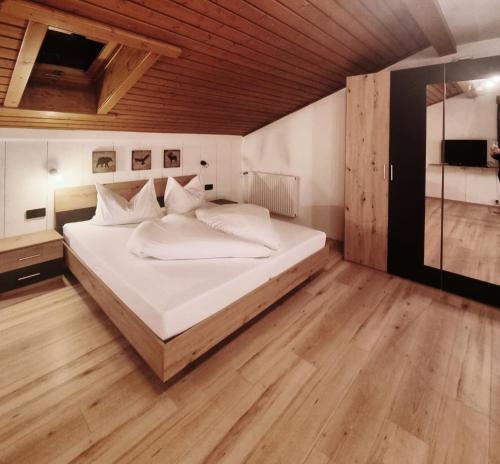 a bedroom with a large bed with a wooden ceiling at Haus Marinus in Jerzens