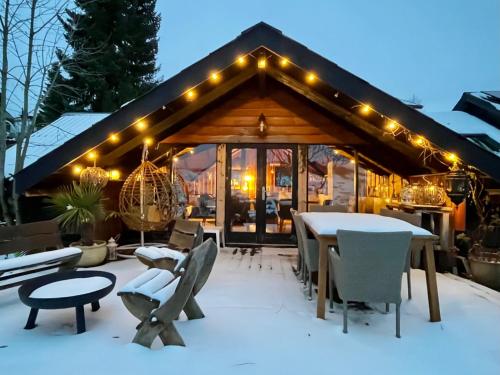 a house with a table and chairs in the snow at Chalet - Kleines Paradies - in Appenzell