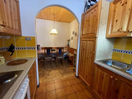 a kitchen with an archway leading into a dining room at A Casa Dei - Appartamento Colle Isarco in Colle Isarco