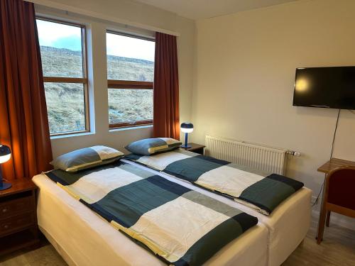 a bedroom with a large bed with two pillows at Staðarflöt Apartments in Hvammstangi
