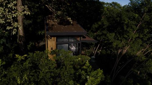 a small house in the middle of trees at Tiny Home Samambaia - Sea view and bathtub in Alto del Espino Prieto