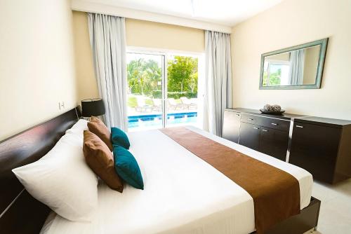 a bedroom with a large bed with a large window at Private Iberosta Villa Fortuna - 4BDR, Pool & Private Beach in Punta Cana
