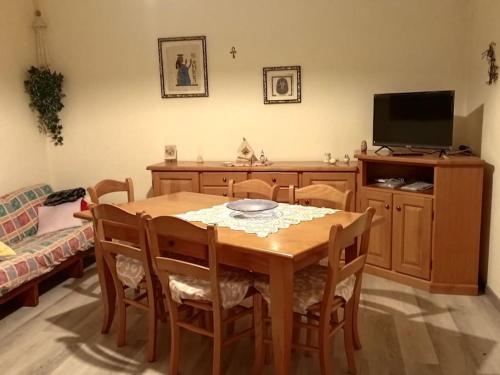 a dining room table with chairs and a television at Casa Il giardino in Ca degli Oppi