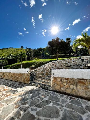 a stone wall with the sun in the sky at Finca vacacional los tres nevados en Melgar in Melgar