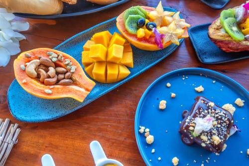 a table topped with blue plates with food on them at Awe Villa Boutique Trancoso in Trancoso