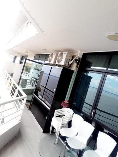 Tropical executive Ap 1411 في ماناوس: غرفة بها كراسي بيضاء وطاولات على شرفة