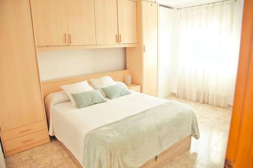 a bedroom with a white bed and a window at Apartamento Playa Xilxes in Xilxes