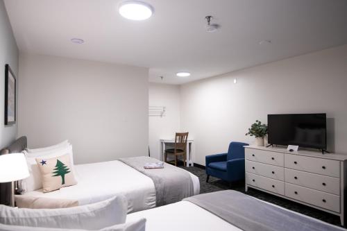 a hotel room with two beds and a tv at Main Street Motel in Bar Harbor