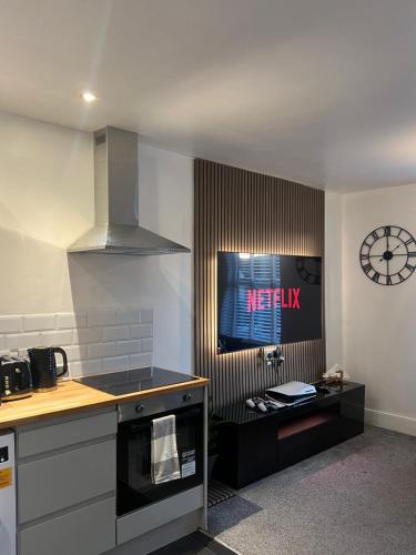 a kitchen with a stove and a clock on the wall at Modern 2 bed flat Southampton- Close to Central Station & Shops in Southampton