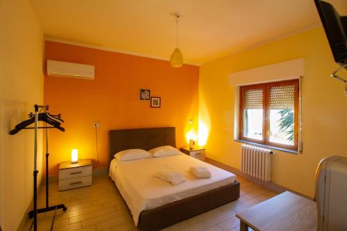 a bedroom with a bed with an orange wall at Il Posto in Pulsano