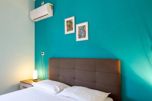 a bedroom with a blue wall and a bed at Il Posto in Pulsano