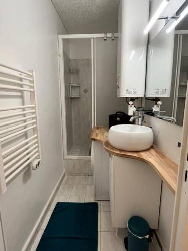 une salle de bain blanche avec un lavabo et une douche dans l'établissement BARCARESA-Appartement face mer et piscine wifi clim garage, au Barcarès