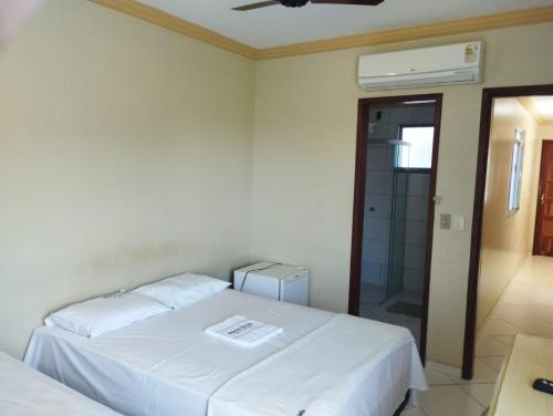 a bedroom with two beds and a glass shower at Hotel Algaroba Anexo in Bom Jesus da Lapa
